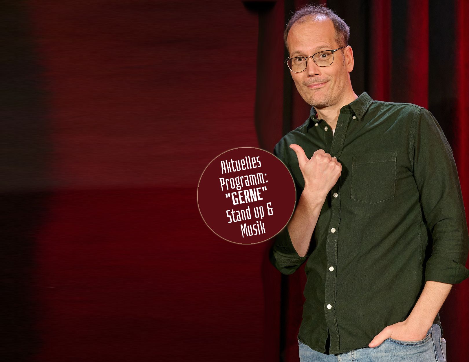 Mario Siegesmund auf der Bühne, Daumen zeigt auf den Hinweis: Aktuelles Programm „GERNE“ – Stand up & Musik